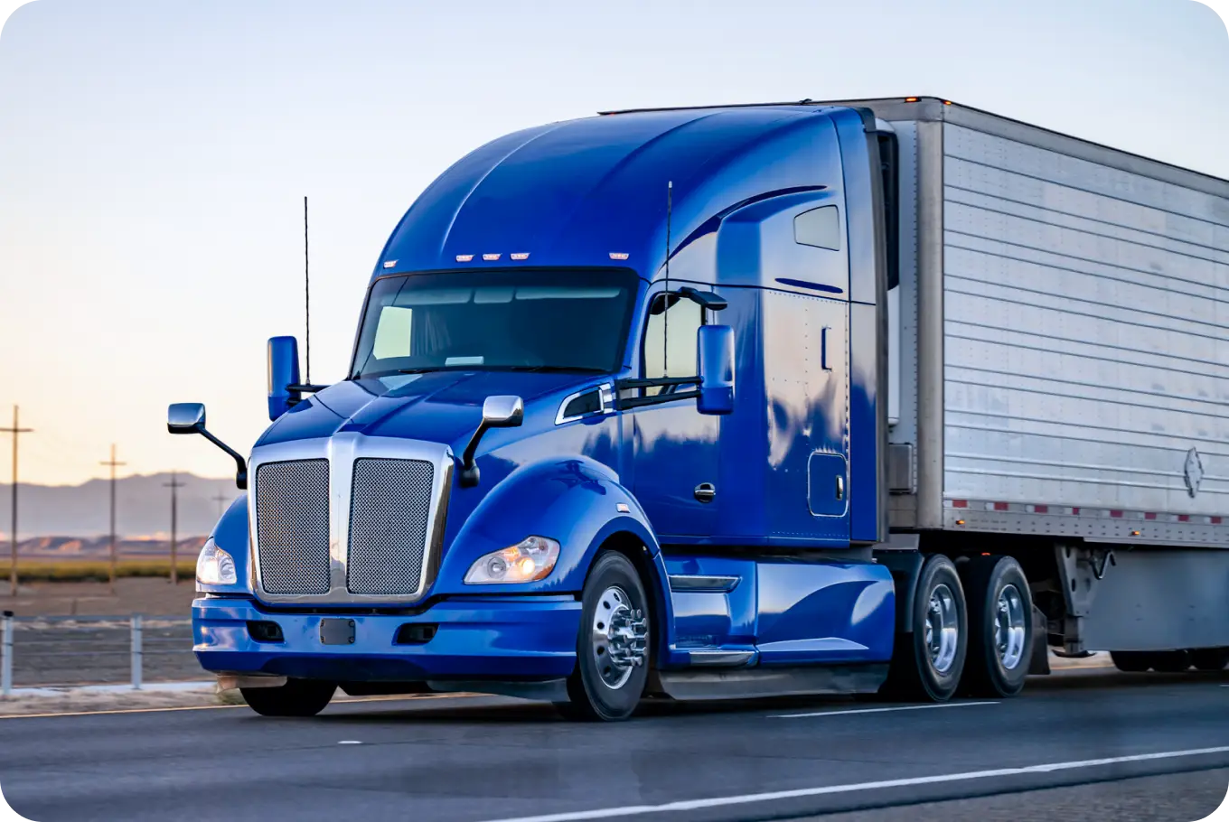 a blue refrigerator truck driving on a highway. the image is used to illustrate that rand mcnally digital products are meant for truckers