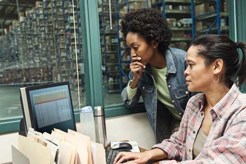 Two logistics workers in shipping warehouse